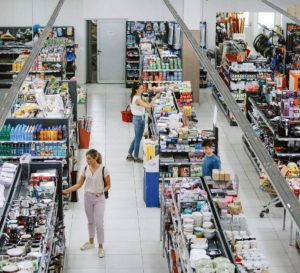 Shoppers browsing aisles in a well-stocked retail store, highlighting the need for reliable security camera systems to monitor customer activity and protect merchandise.