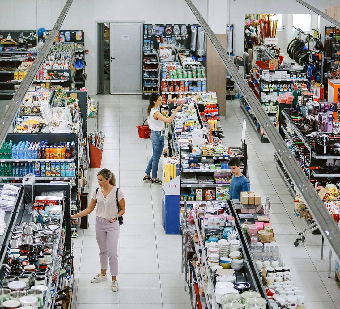 Shoppers browsing aisles in a well-stocked retail store, highlighting the need for reliable security camera systems to monitor customer activity and protect merchandise.
